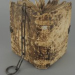 <a href='http://www.ra.ee/pargamendid/index.php/et/parchment/view?id=14994&_xr=eNoti0kOQFAQRO%252FSB%252Fg0gpSVvaULdL42JOZhJe7Ox%252Bq9ekkJGGcHPxNEn2zgGDTLattBx93b1Ck9PQGtWtupUrc4BJVFboLQN2zsEL0RtPxkxxTUy9gc0ryfAKQ7Zdd1A03rIuc%253D' target='_blank'>Ürik TLA.230.1.cm4</a>, 13. saj. </br>
Köidetud pärgament.
Keskaegse ahelköite roostes metallpanus, mis pikaajalises kokkupuutes pärgamendiga on tekitanud kahjustusi.
